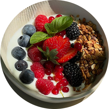 Servizio colazioni presentato con un piatto con yogurt del luogo, cereali, more, lamponi, mirtilli, fragole e menta, nel ristorante da Alcide a Venturina, in Toscana.