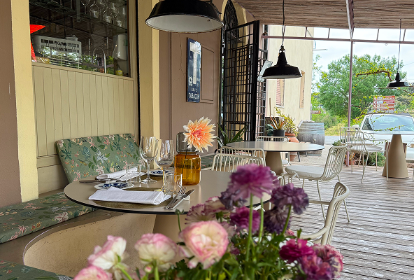 Tavoli e postazioni all'esterno del ristorante da Alcide, sotto una tettoia di glicine