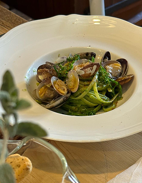 Primo piatto ci spaghetti al cavolo nero con vongole e prezzemolo.