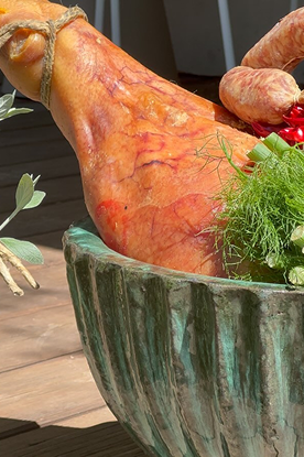 Prodotti freschi, prosciutto, salsicce, finocchi e peperoncino in un recipiente