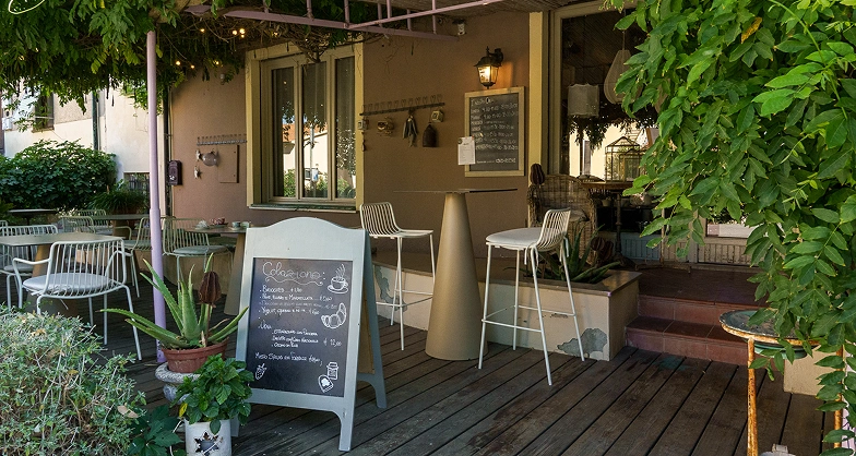 An outdoor area under the wisteria canopy where you can enjoy breakfast at Alcide’s in Venturina.